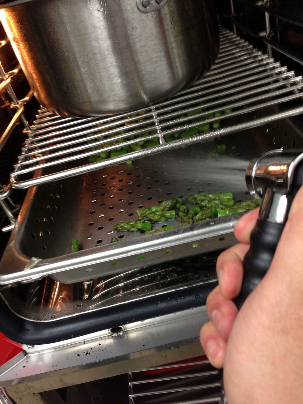 After 3 minutes, use the hose to shock the asparagus, and then remove the asparagus.