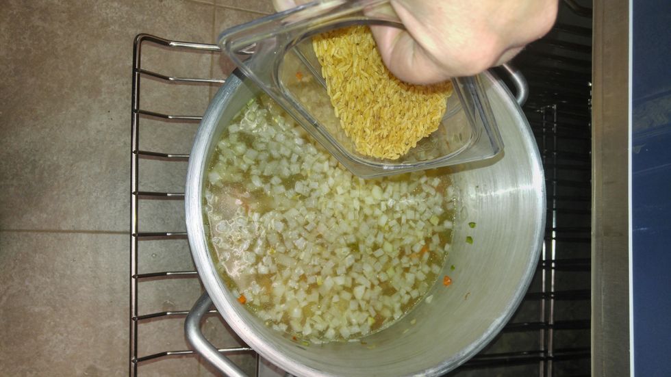 After 30 minutes add rice and stock and thyme to the pot.