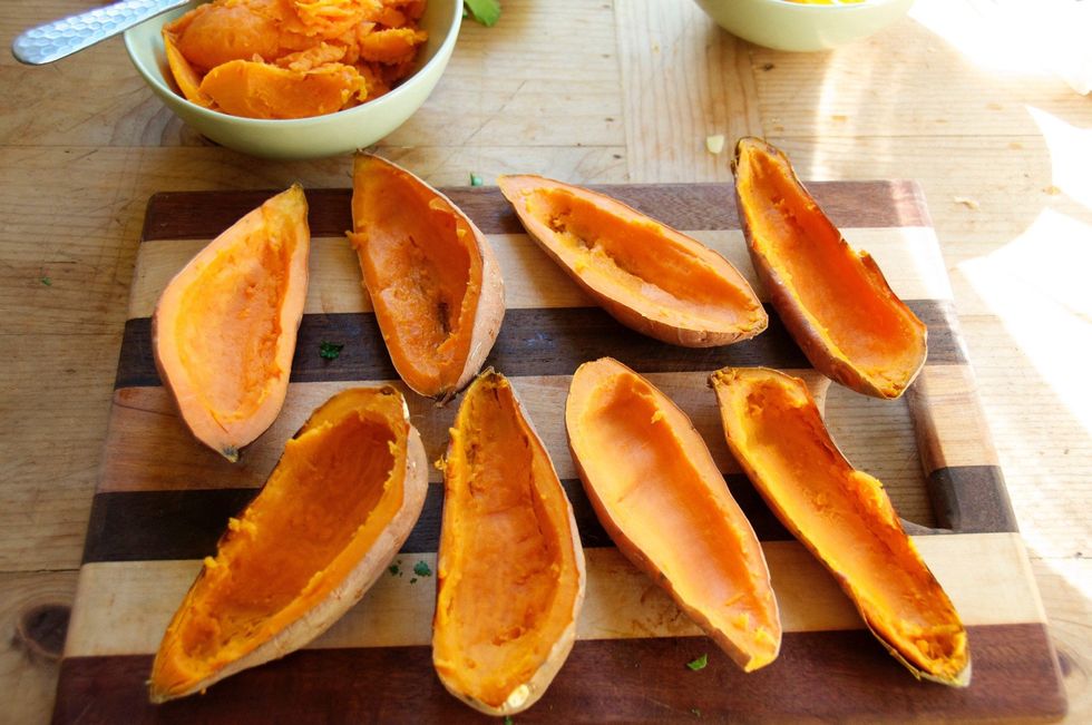 After 50-60 minute of baking your potatoes, remove from oven and let the, cool a bit so you can touch them. Cut each one in half then gently take a spoon and scrape out the middle but not all of it.