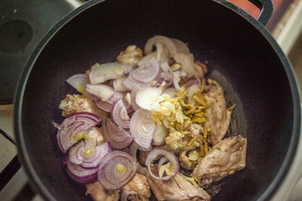 After about 1minute add the onions, ginger and garlic. Continue cooking so and to brown the chicken.