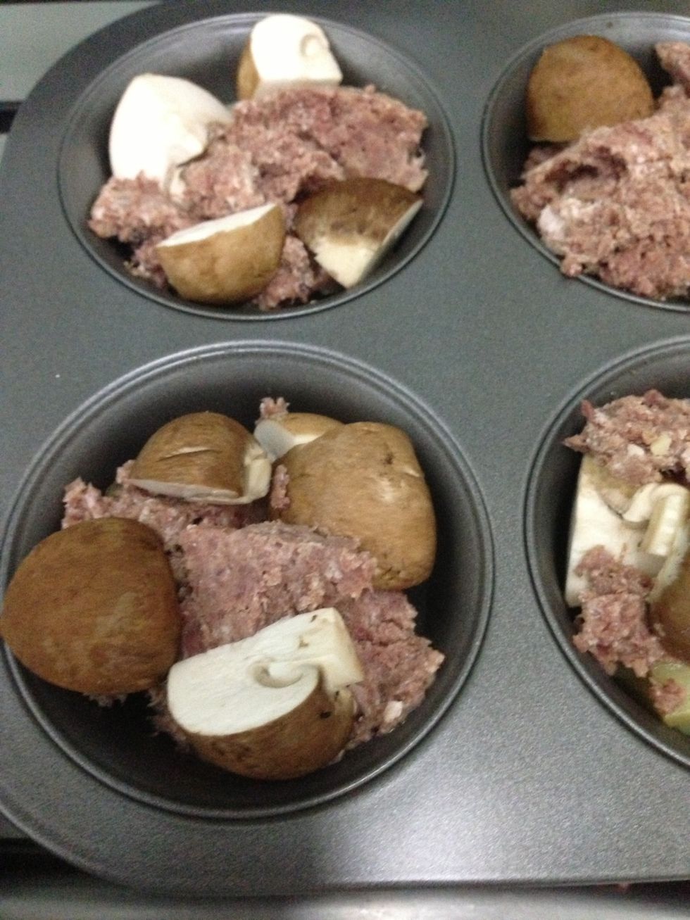 After about 5-10 mins, take out the muffin tin and put in the meat (whatever you can find in your kitchen) and vegetables on top of the potatoes. Put the muffin tin back into the oven