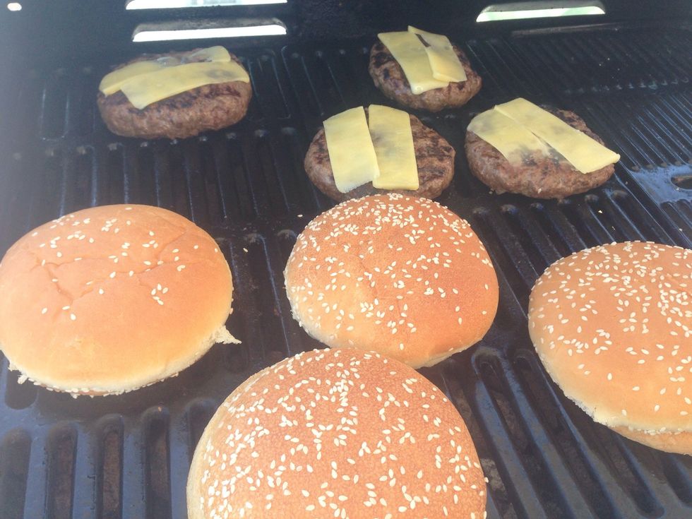 After about 6 minutes (flipping every 2), place your choice of cheese on top and warm up your bread buns. I buy American style buns that are thinner and less spongy than the regular buns you find.
