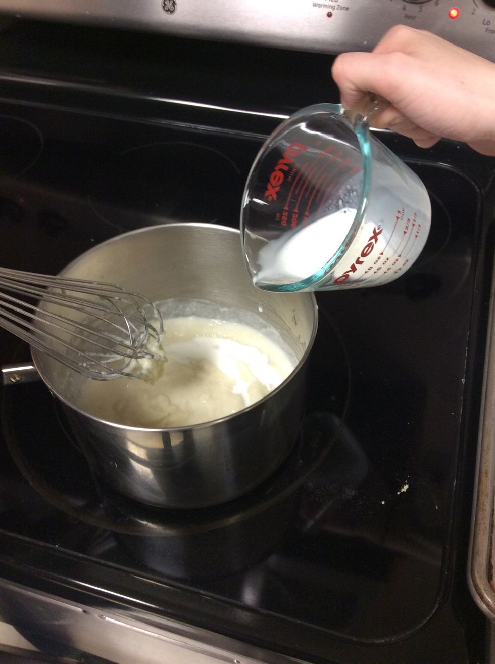After about four minutes gradually pour in 2 cups of milk and 1/4 cup heavy cream. Whisk constantly as you add the milk and cream.