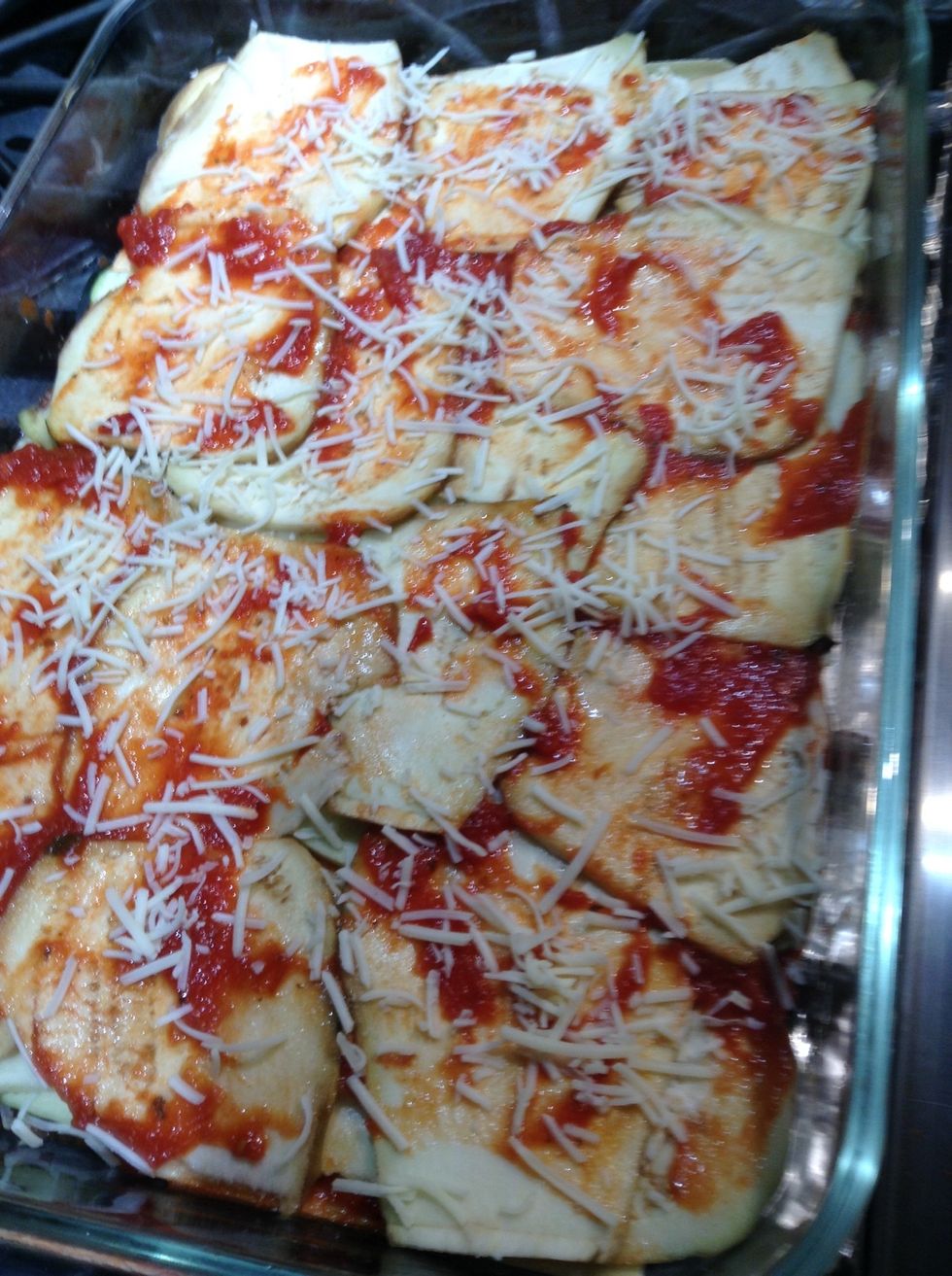 After adding all the eggplant (include a dotting of ricotta between layers) put down a light layer of sauce and sparsely sprinkle with asiago cheese.