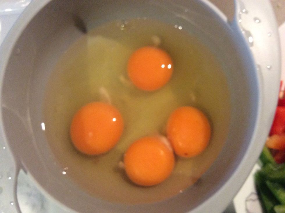 After adding the potato to the oil, crack the eggs into a bowl and stir them.