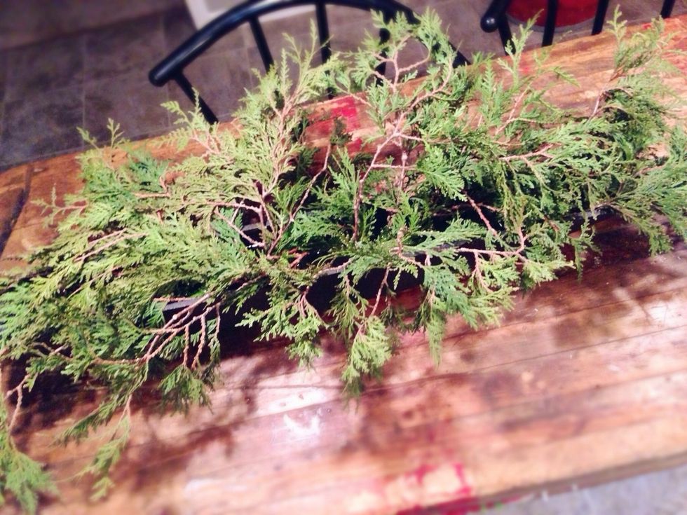 After adding your evergreen leaves, the vessel should be full, but not overly crowded. There are still a number of items to add, so make sure to leave some room.