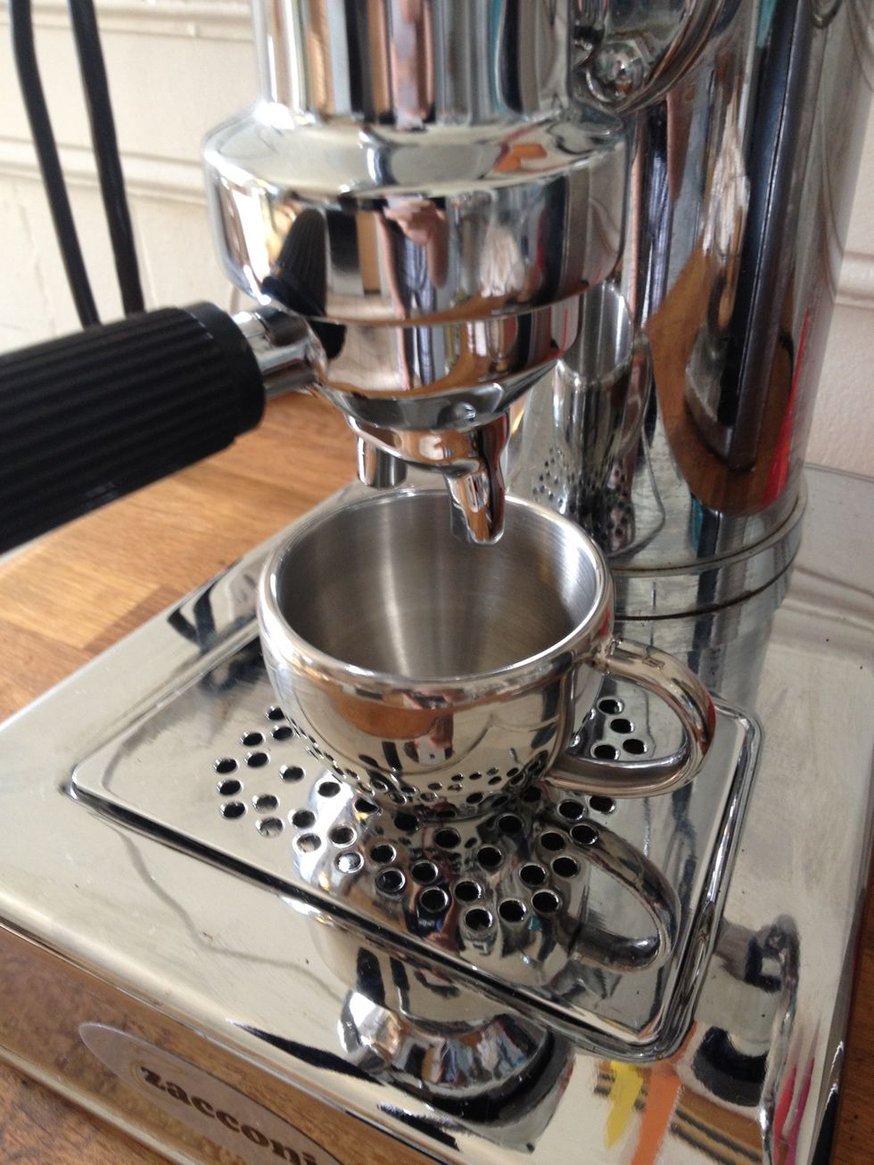 After all that hard work, it's finally time to pull the espresso! Place the cup so it will catch both streams from the portifilter.