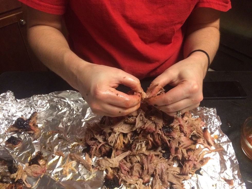 After an hour, remove the butt from the foil container. Using your hands or a fork, shred the meat into bite size portions.