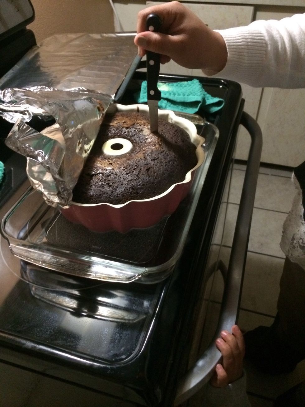 After an hour take out cake, uncover it, insert a clean knife into cake & if it come out clean it's ready :)