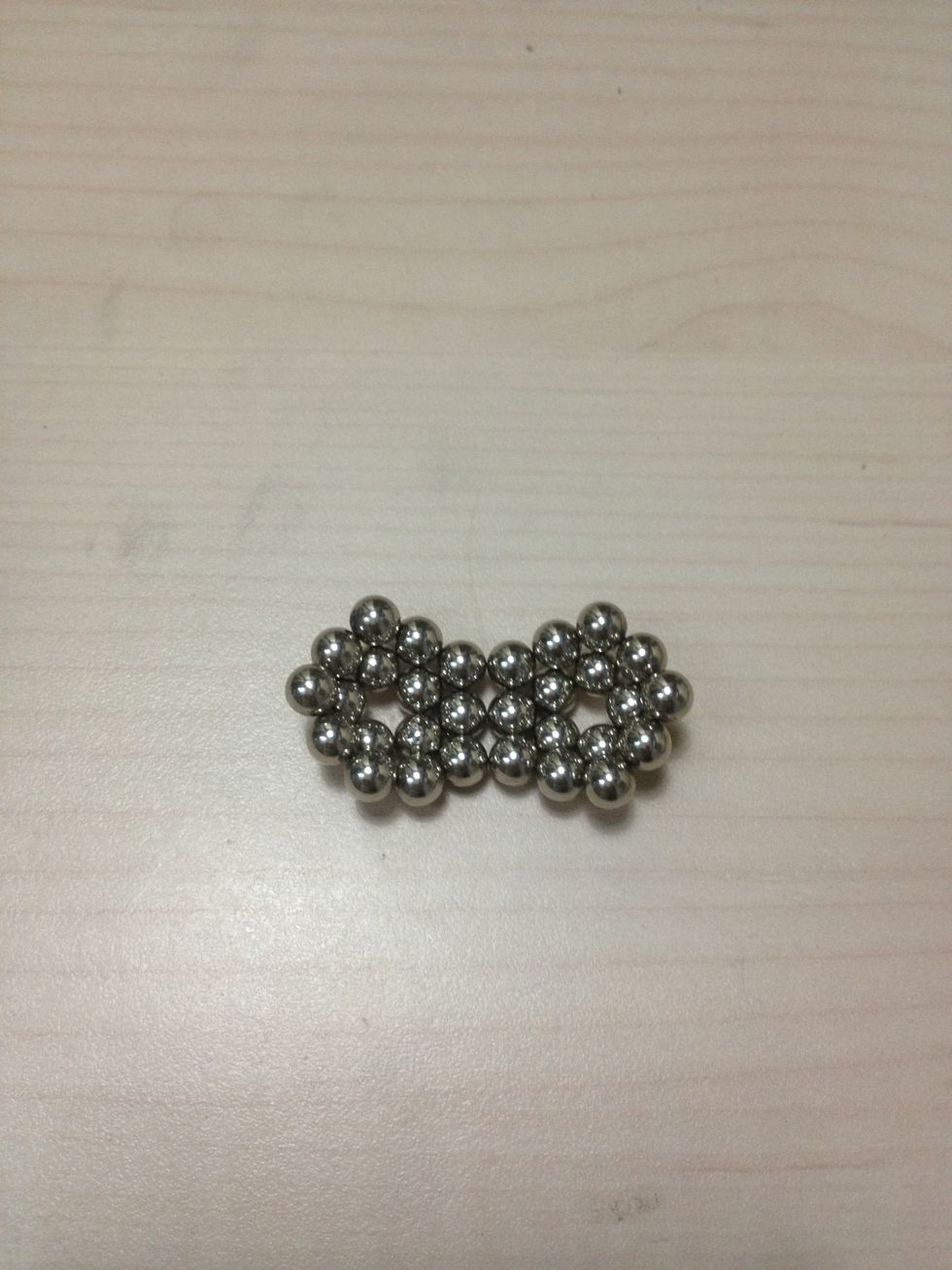 After checking for polarity, stick 2 of these rings along any edge of 3 balls. Make sure they bulge in the same direction
