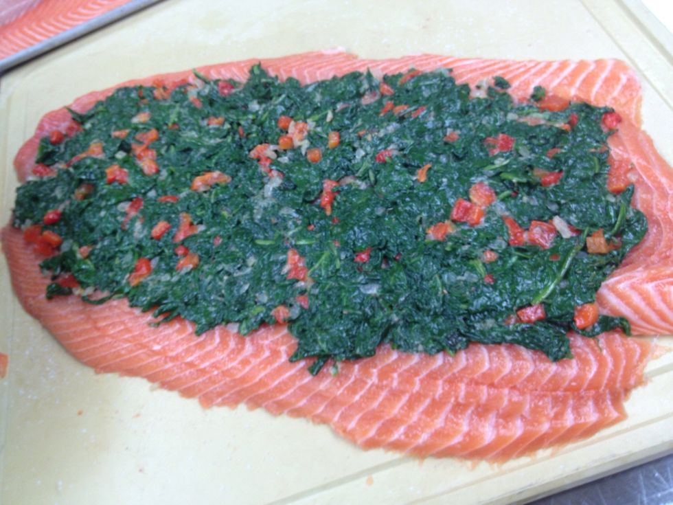 After combining the cooled onions with spinach and peppers spread out on the salmon