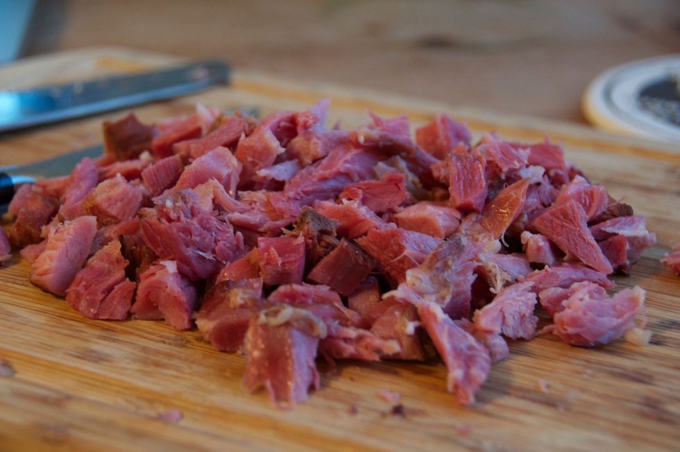 After cooking the peas for about 1.5 hours, remove the ham and strain the peas, saving the broth.  Discard the onion halves and the bay leaf.  After the ham has cooled to touch, remove the meat.