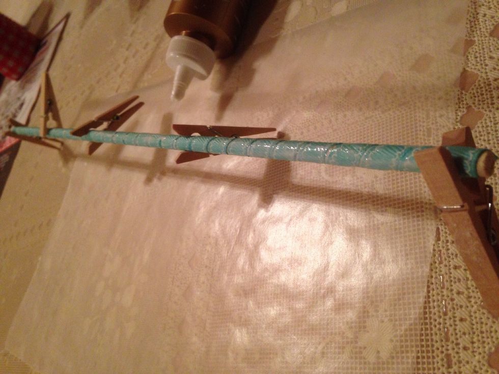 After dowel is covered with ribbon and clothes pins clipped, spread out any glue that has seeped out. Allow a few hours for glue to completely dry.
