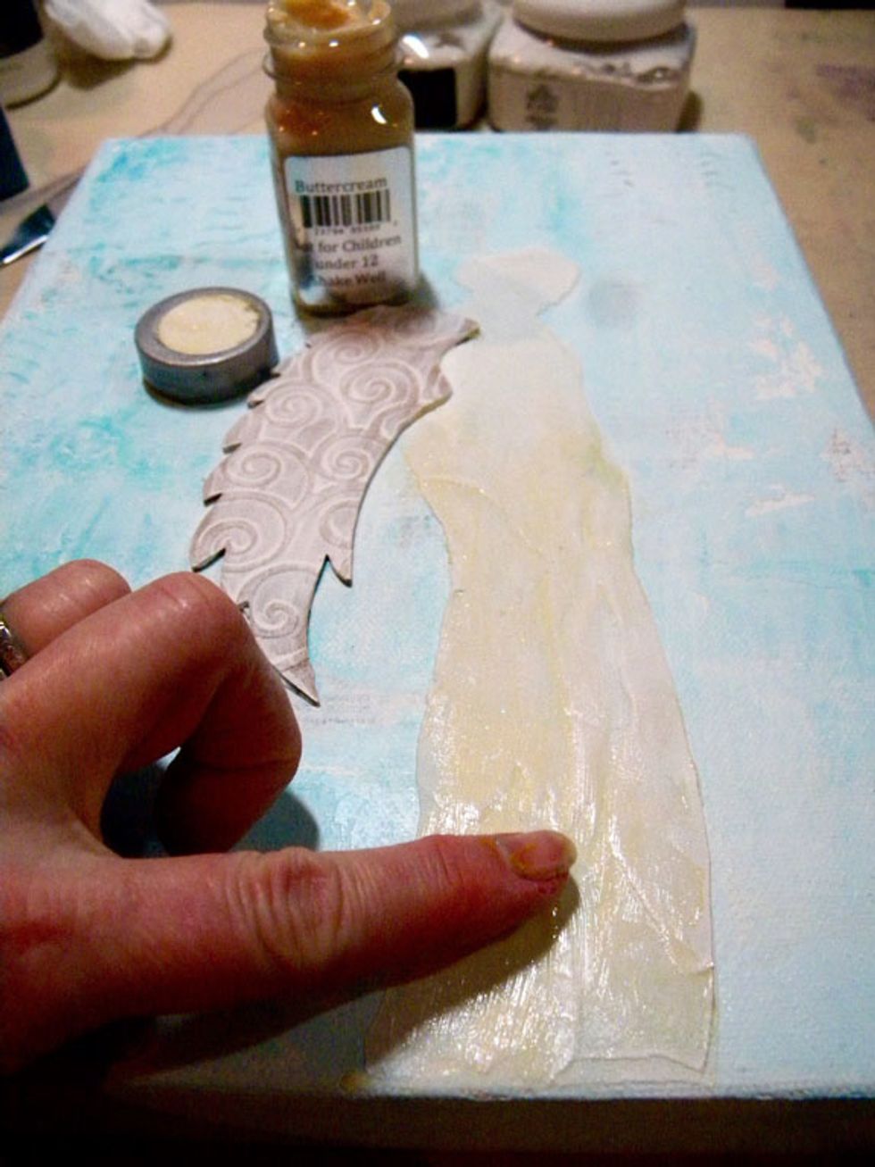 After dry, I decided the silhouette needed more height. I placed the stencil back onto the canvas, lining it up then added a thick layer of Buttercream Sorbet over the existing figure. Let dry.