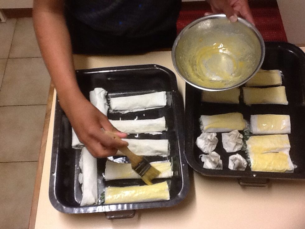 After finishing all the pastry and mixture take them put them into the baking trays and while using the remaining egg yolk whisk it up and using a clean brush cove the top seam side down in yolk