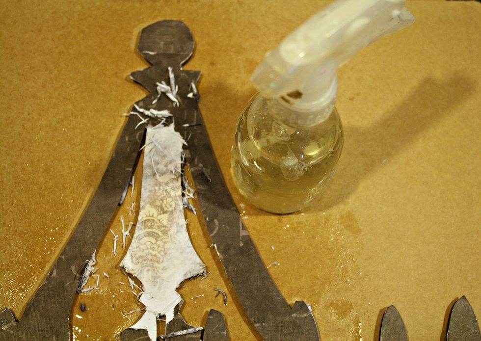 After I spritz with water I gently rub the paper with my fingertips. Start very gently at first, then a little more firm once you start to see the paper layer exposed underneath.