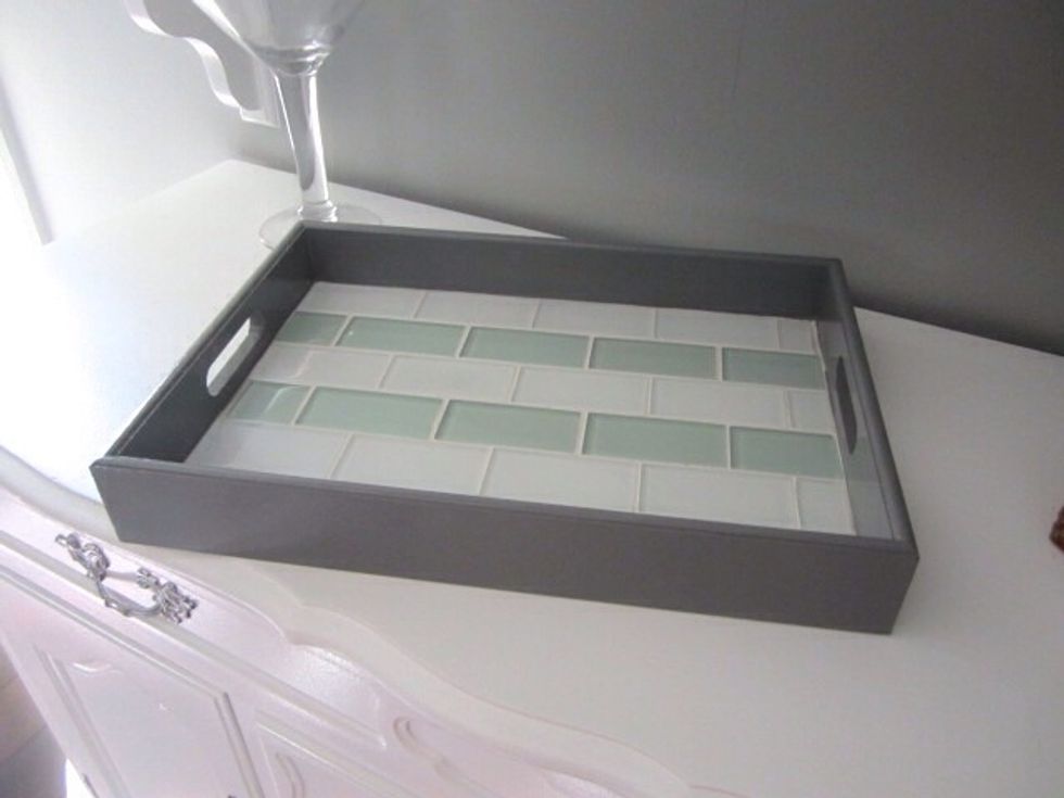 After it's dried (dry time depends on grout) use a damp sponge to wipe clean.