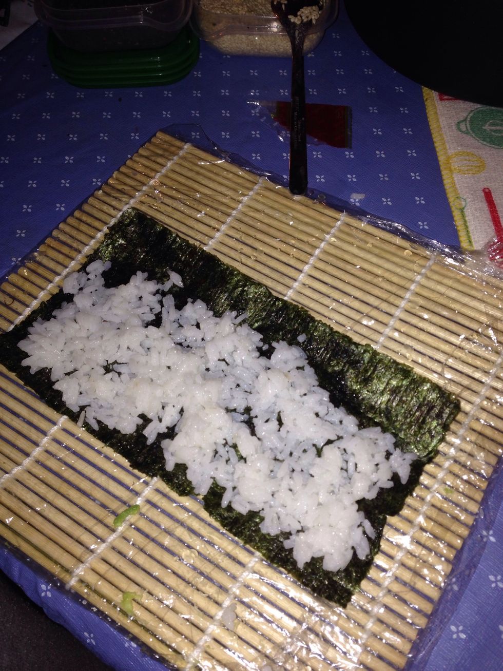 After laying down some rice sprinkle some white and black sesame then flip the seaweed over. I like rice facing outside but u can keep it inside too up to you.