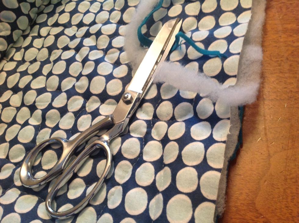 After machine quilting, cut raw straight edges.