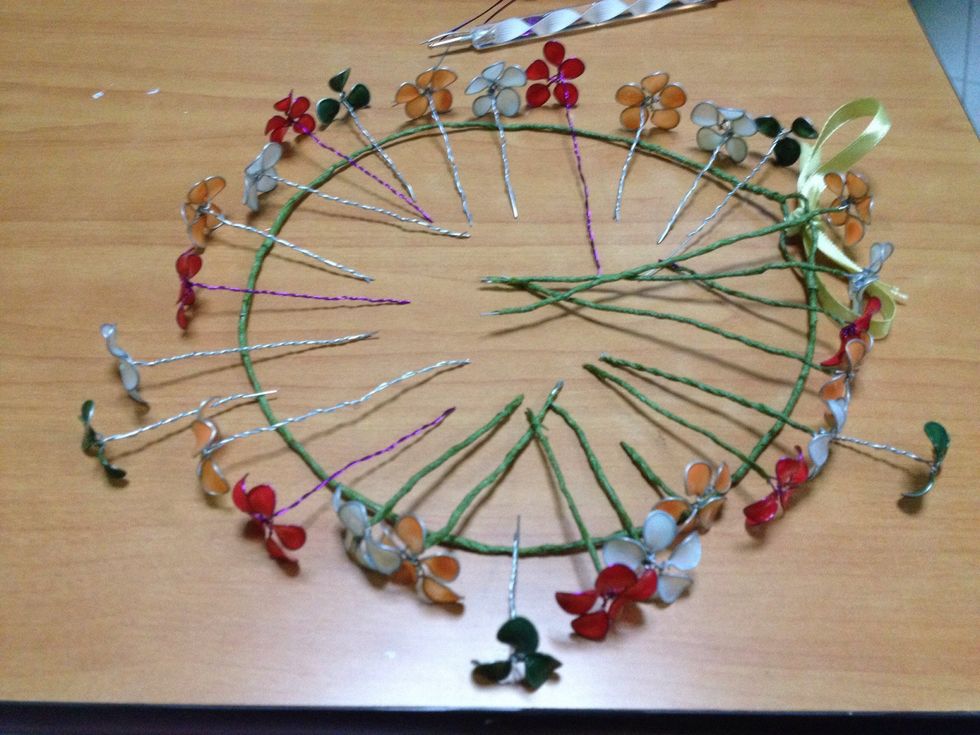 After making flowers of various numbers of petals and colours, line them onto the wreath and gauge how many more is needed. Trust me, you'll need to double the flowers if you bind them closely on the