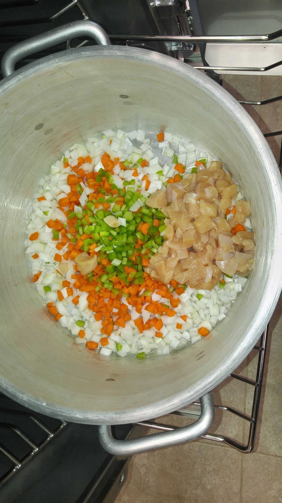 After oven has preheated, add a small amount of oil to the pot, then toss in vegetables and chicken, season lightly, stir together and put back in and close the door.