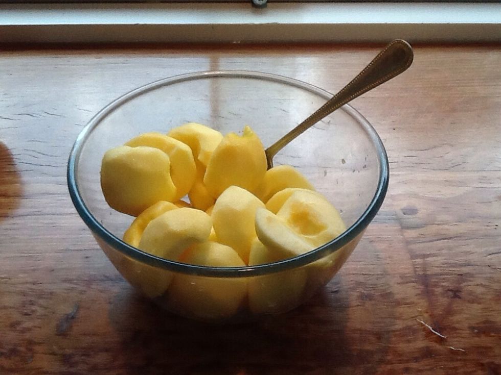 After peeling, halving and coring the apples place them in a bowl with the juice from the lemons. This stops the apples from discolouring.