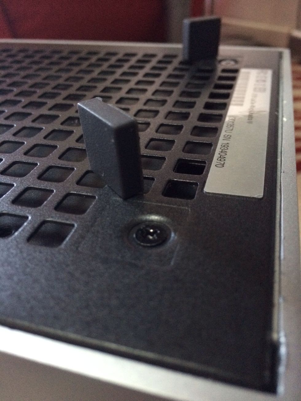 After removing the hard drives on the back: Take off the rubber feet at the front bottom of the casing. You'll find two screws.