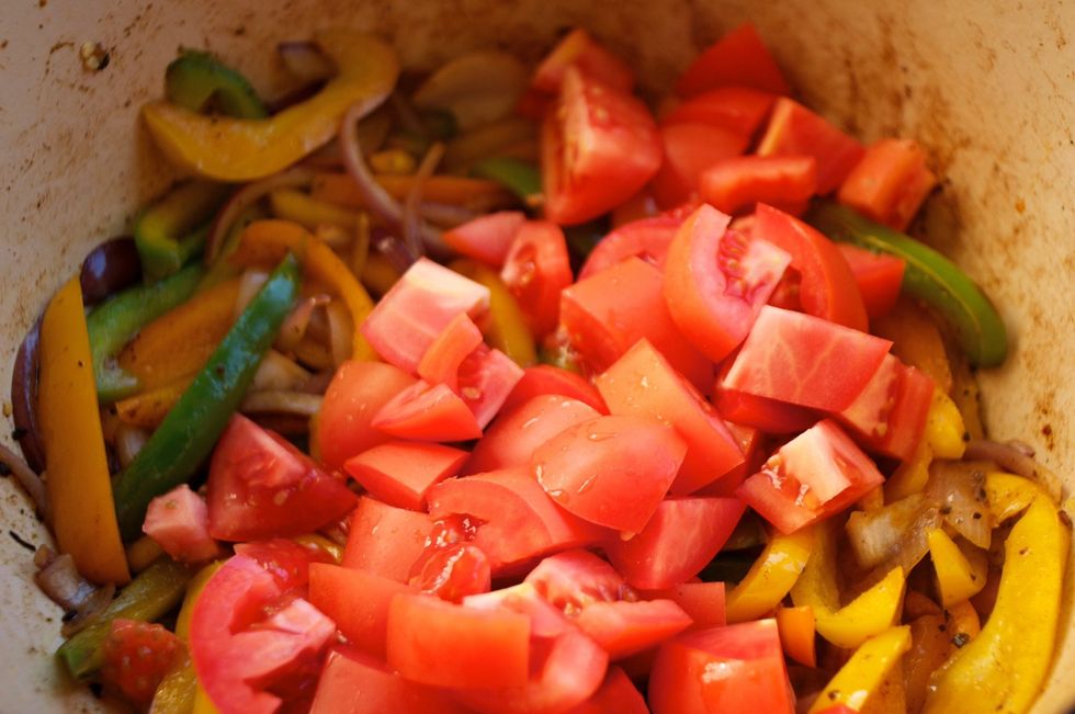 After saut\u00e9ing the peppers and onions for about 10 minutes, add the tomatoes.