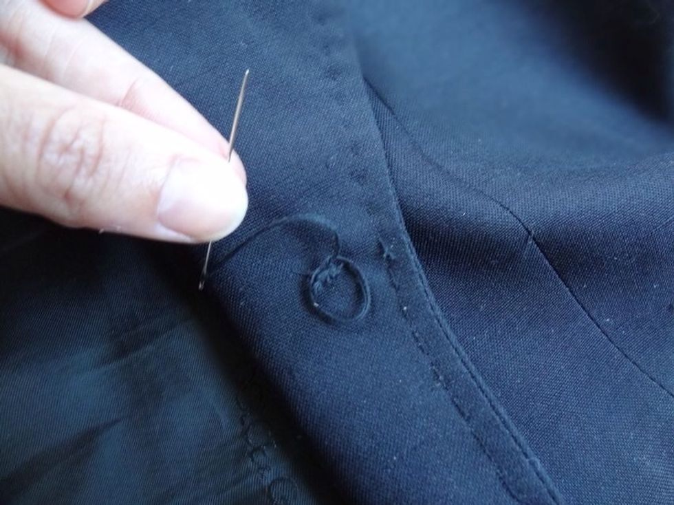 After shanking, loop your needle back through to the underside of the jacket. Loop needle through existing threads a few times, tie it off, then repeat. Complete process by cutting off excess thread.