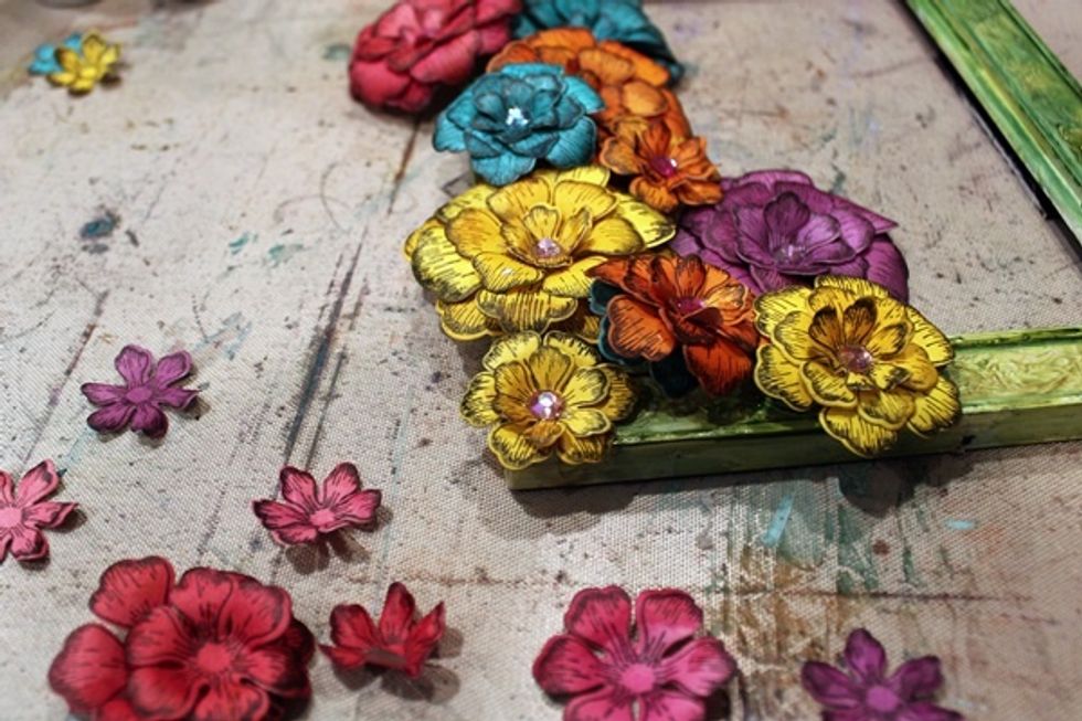 After shaping all the flowers, begin layering and placing them around your frame. As you can see I added a bit of bling to my flowers to finish hem off.