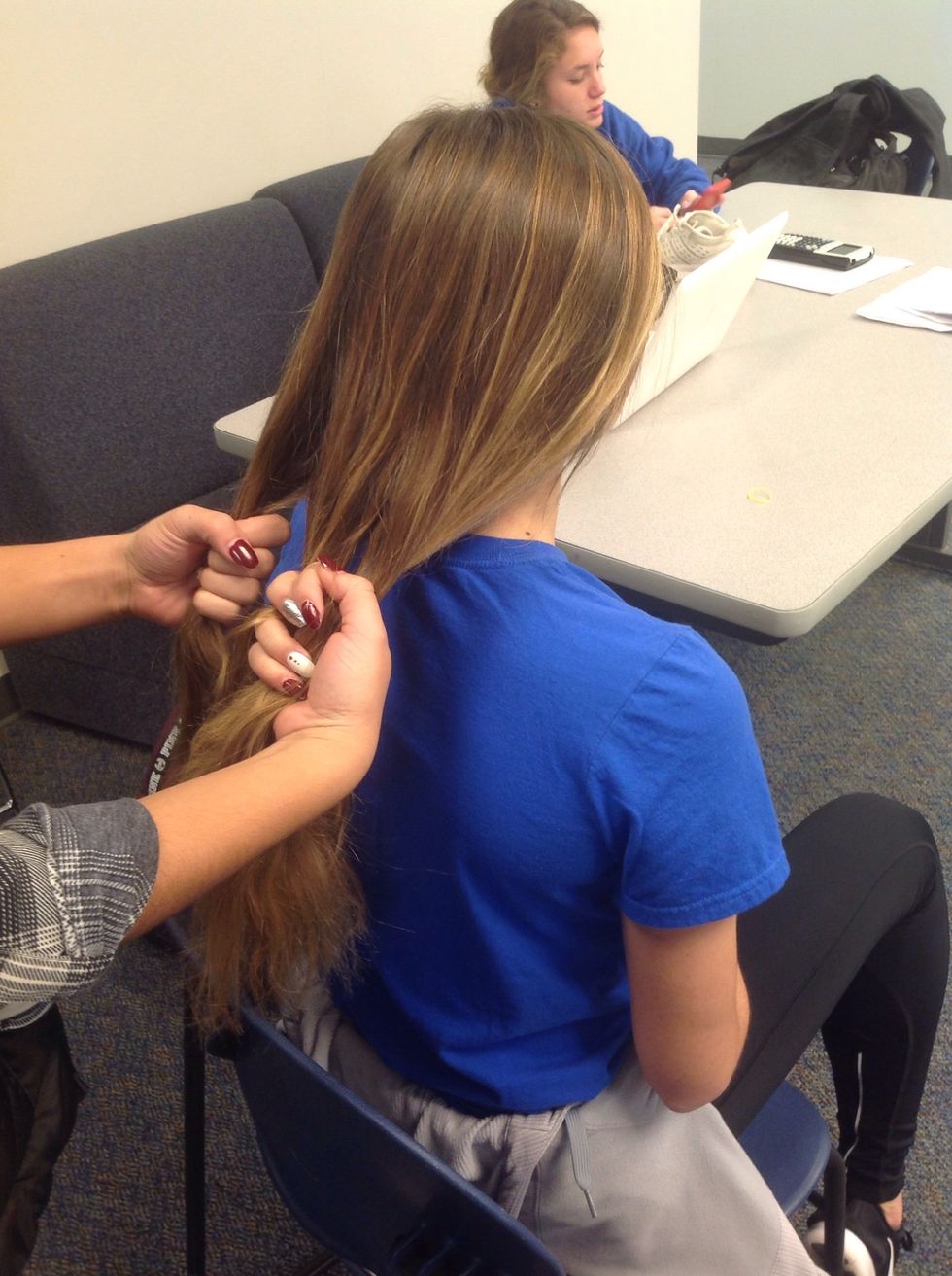 After splitting the hair hold one piece in one hand and the two in the other hand. Make sure you have one outside piece on one side and the middle and other outside piece on the opposite side.