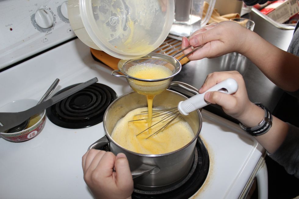 After, strain the egg mixture though a sieve and whisk gently in the milk and sugar mixture.