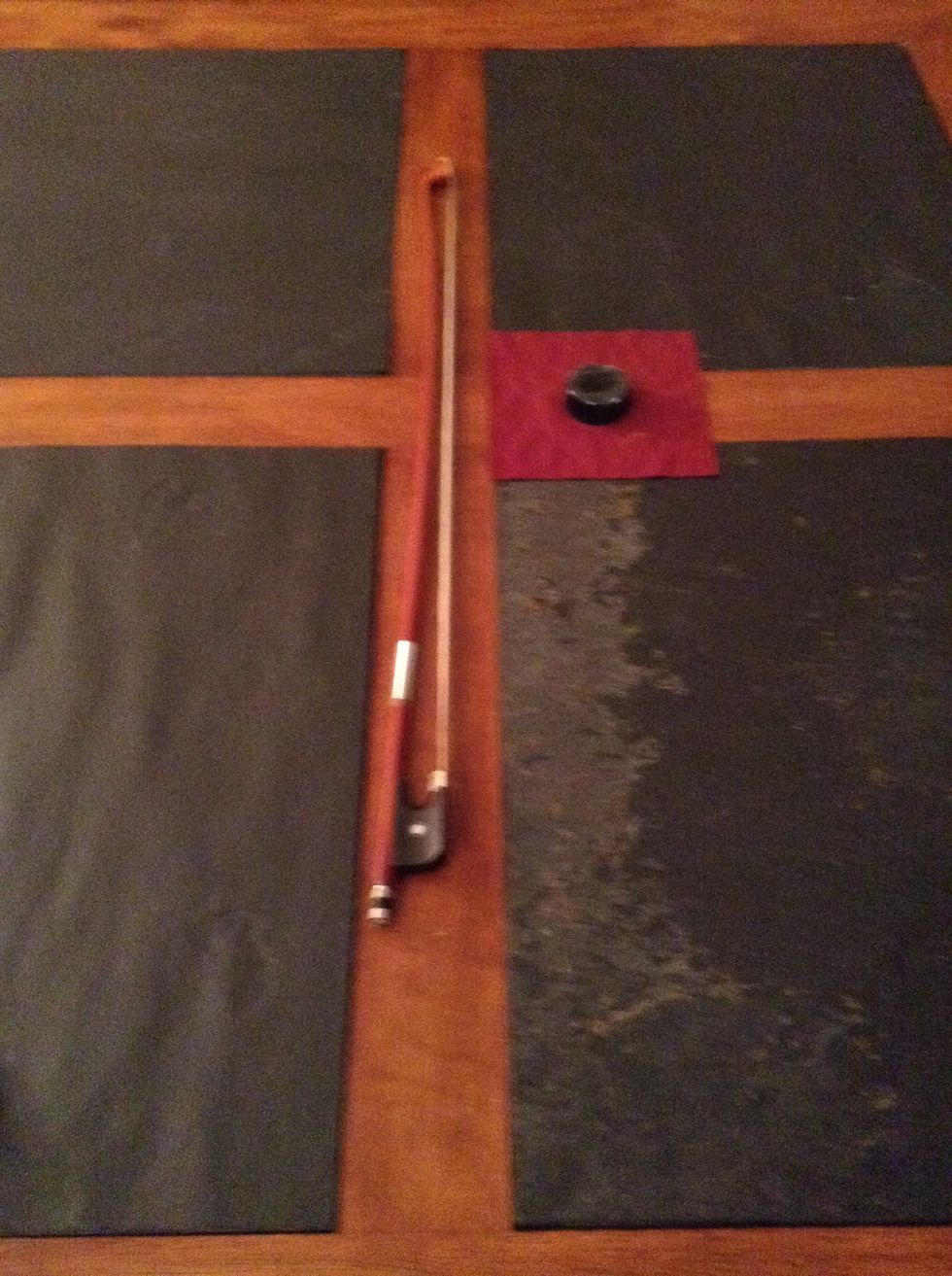 After, take the bow and rub the rosin (the black circle) on the bow.
