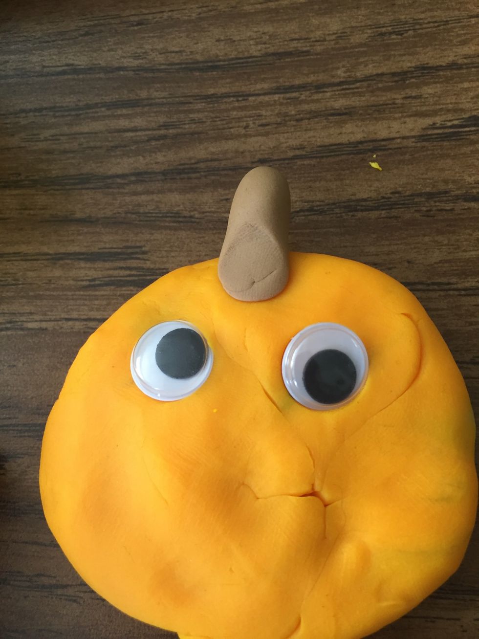 After that, add 2 wiggly eyes to the pumpkin.