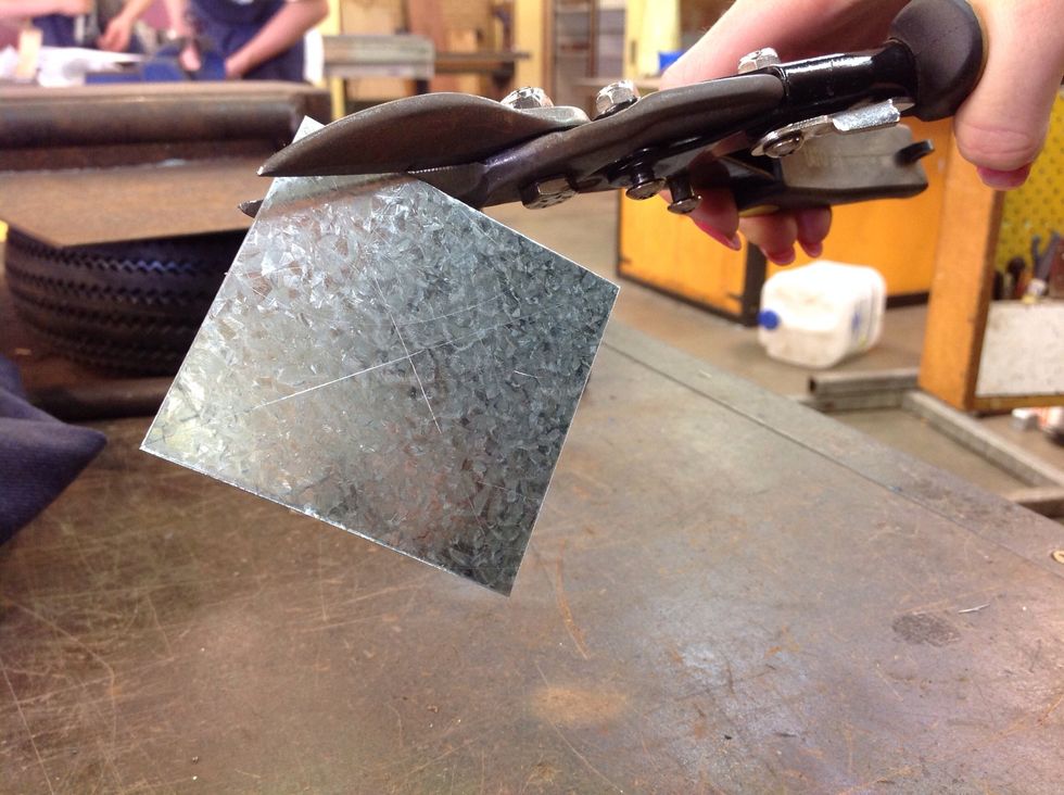 After that get the tin snips and cut the circle into shape.