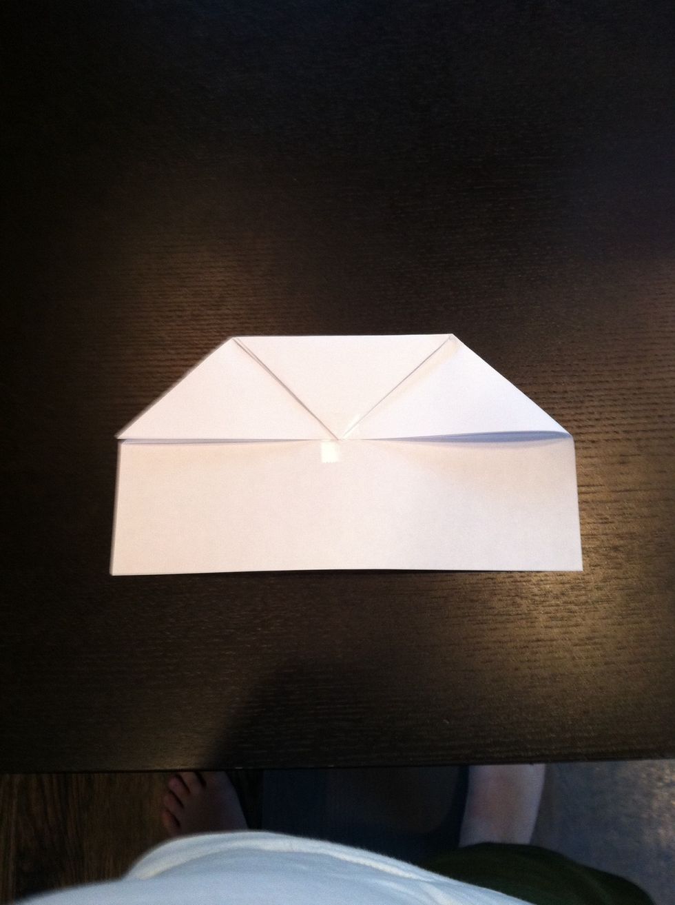 After that you fold down the tip of the paper to about where the rectangle and triangle meet.