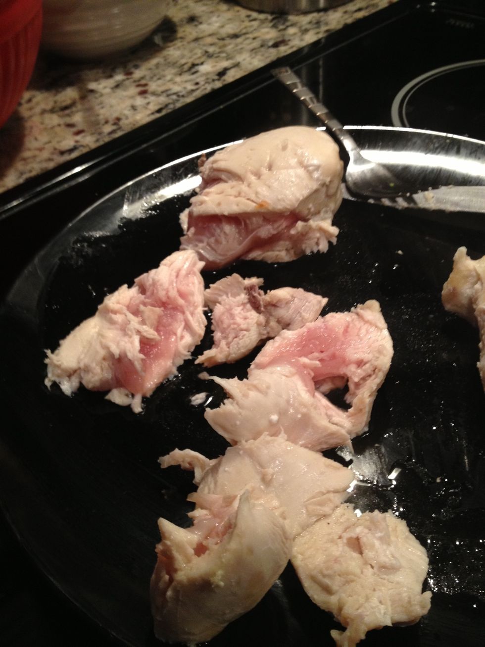 After the 8 minutes, remove the chicken and cut into small pieces. Place the pieces into the blender and blend into small strands.