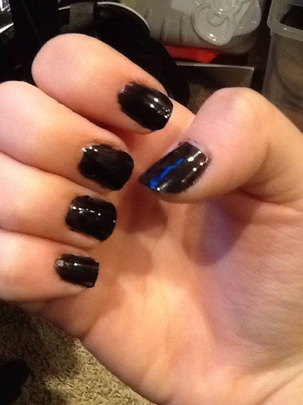 After the base coat has dried, put on the black nail polish.