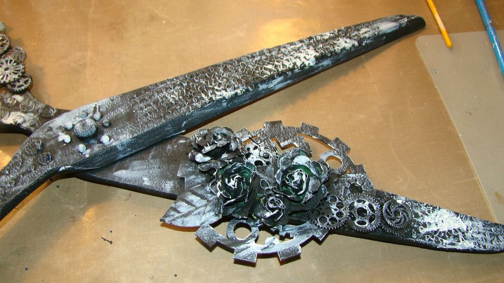 After the black gesso has dried, brush on a light coat of white gesso here and there. This will enable the paints and sprays to highlight different shades and shadows on your project.