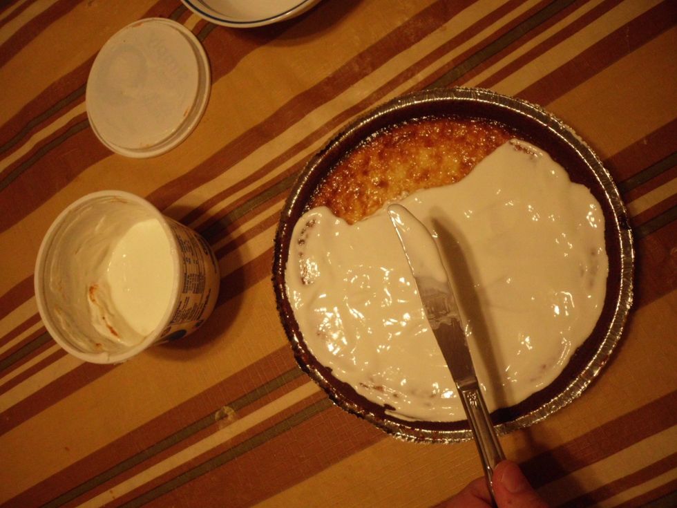 After the cheese cake is out, as well as the sour cream. The next step is to spread the sour cream on top of the cheese cake, but be sure not to make the sour cream overpowering.