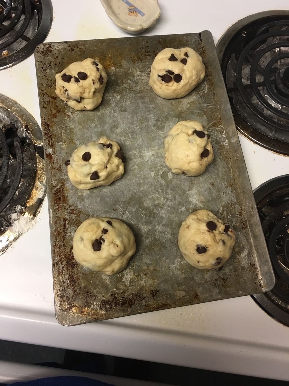 After the dough has risen, spray baking sheet with nonstick spray or wipe oil on sheet, then start shaping the dough into little balls and place them on the baking sheet about 1 inch apart