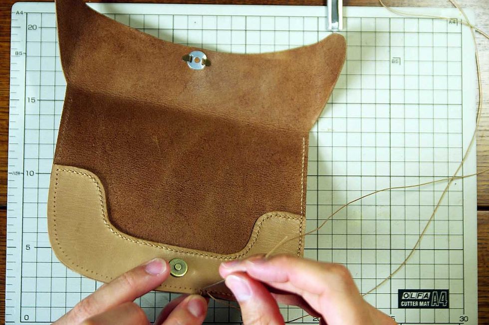 After the glue has dried, sew it with the wax cord.