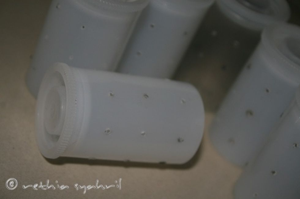 After the nail is hot enough, push it through the film canister until it make a small hole.