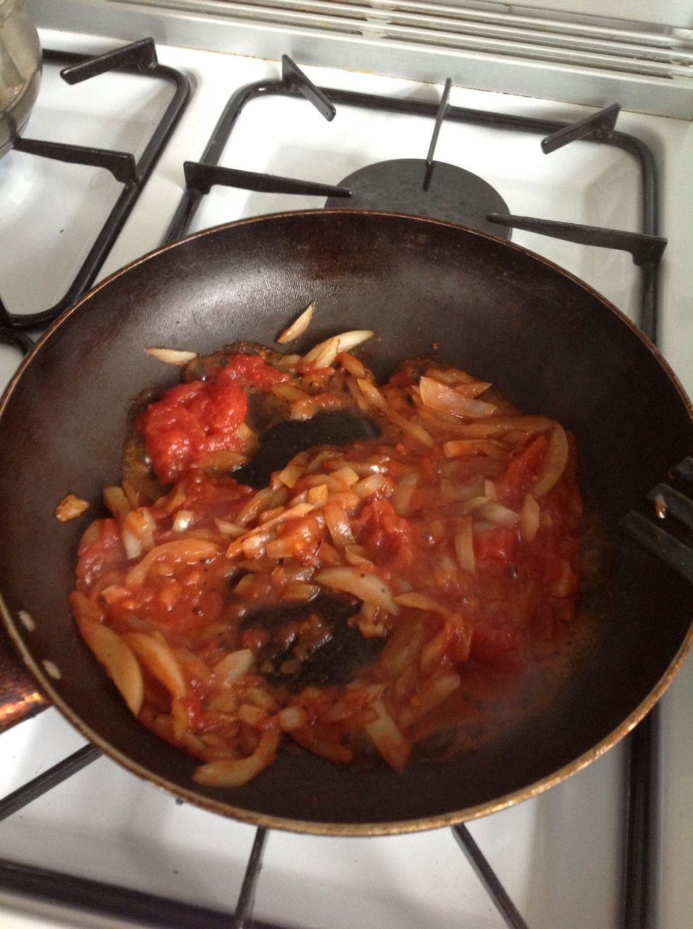 After the onion has softened pour in tomato puree or sauce. Stir for 2min then add in chic peas