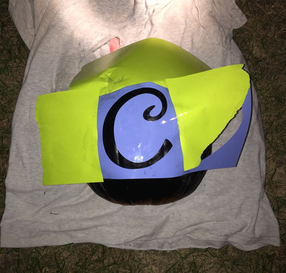 After the paint has dried, tape the stencil down and cover edges with paper to avoid mixing paint colors.