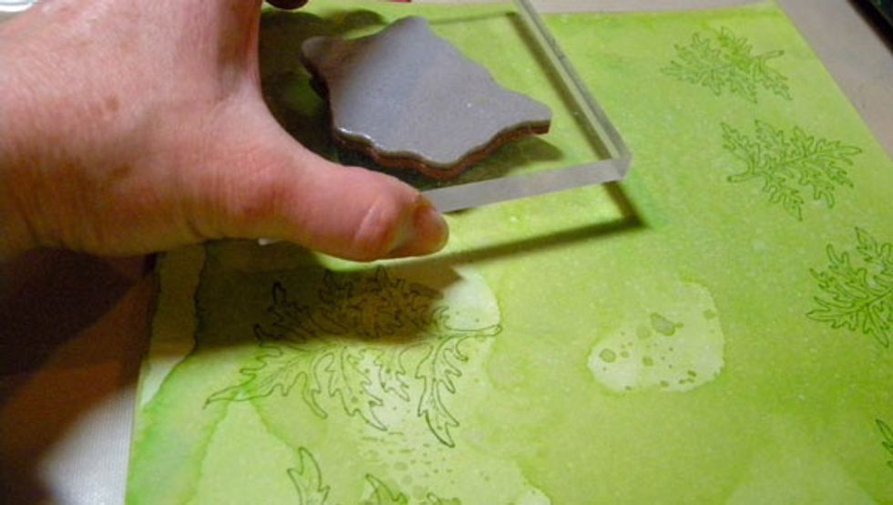 After the paper is completely dry, stamp with Heartfelt Creations leaves on the green paper and flowers on the yellow and purple papers.