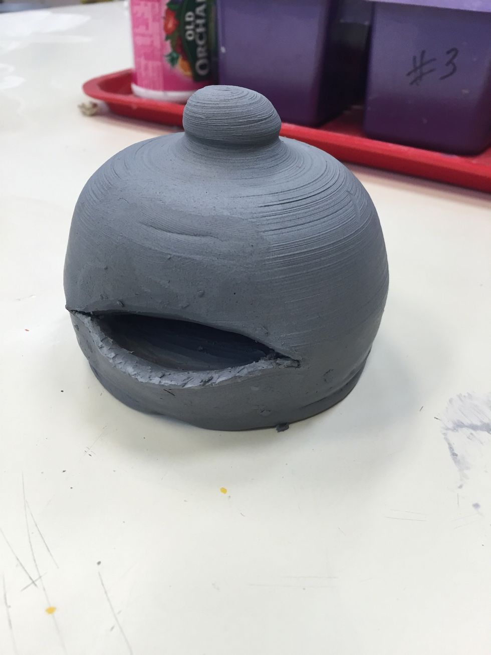 After the piece has dried for a day, cut a horizontal slit about 3 inches long. Press in the top portion above the slit in at an angle. And pull the bottom part out so that it angles up and out.