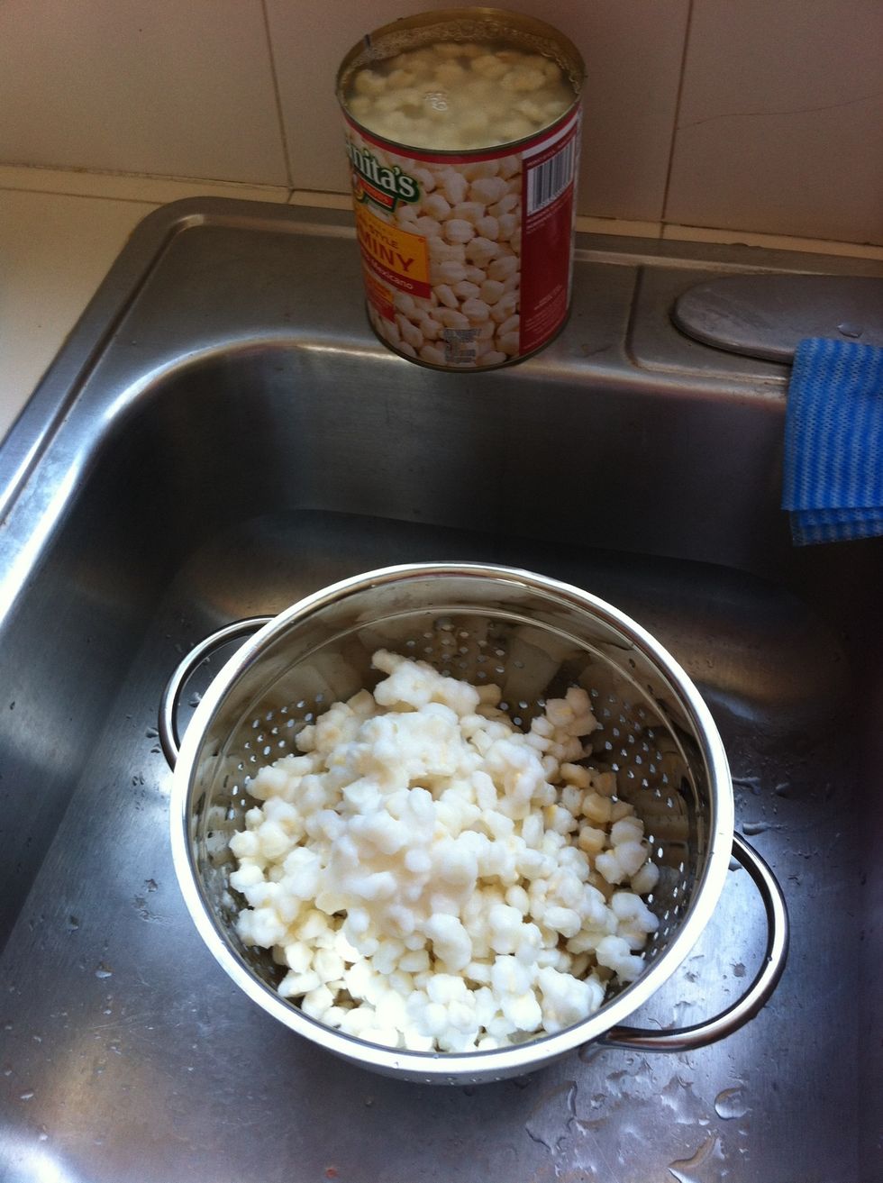 After the pork has cooked about an hour, drain and wash the hominy.