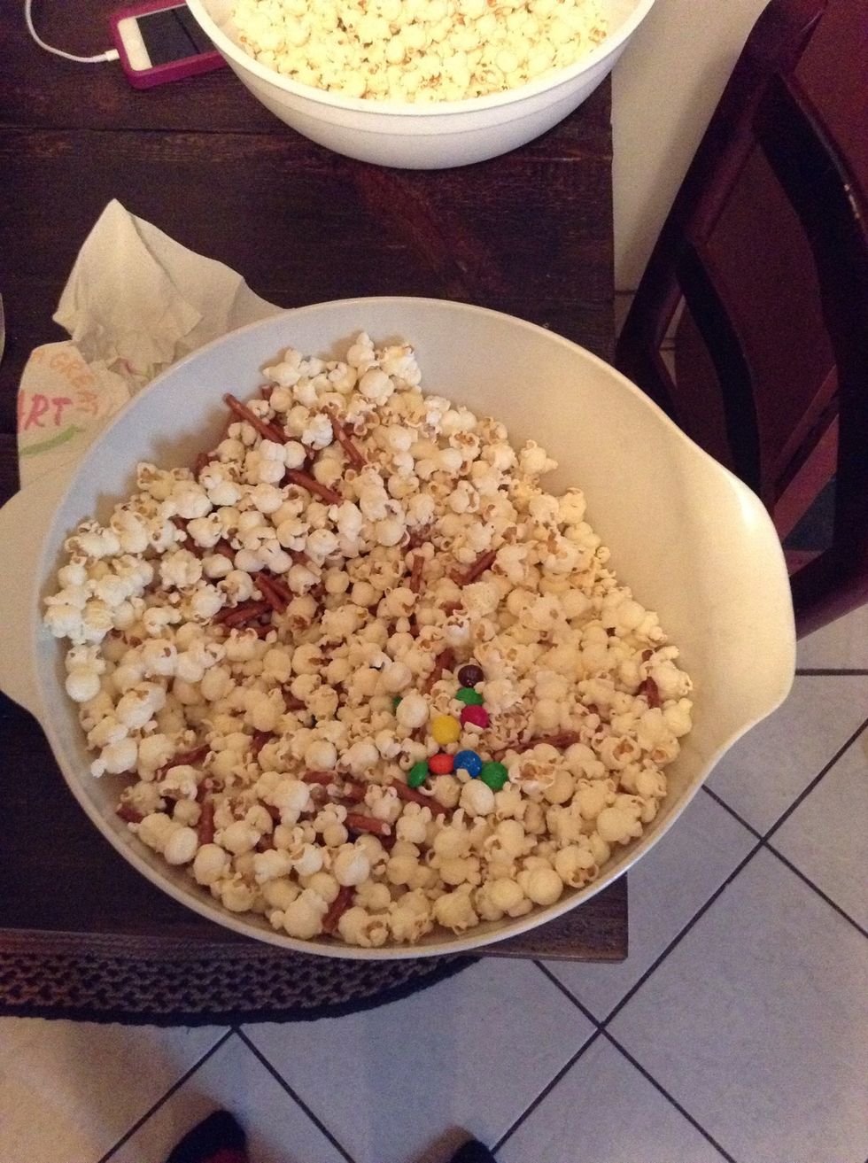 After the pretzels are broken up, mix them into the bowl of popcorn and M&M's.