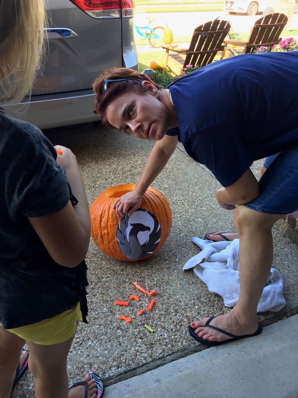 After the pumpkin seeds are removed, tape a spooky picture on the pumpkin.